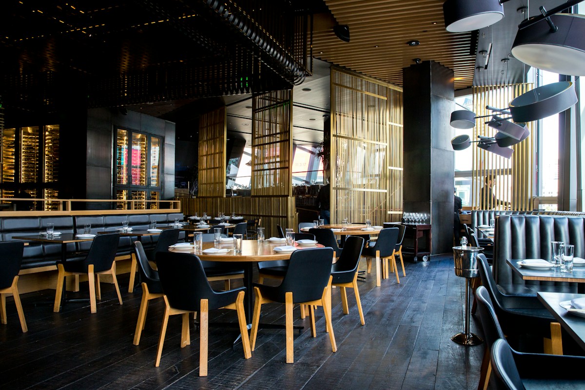 Warm restaurant interior with wooden tables and hanging lights